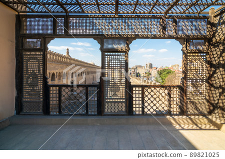 Passage surrounding the Mosque of Ibn Tulun framed by wooden window, Mashrabiya, Cairo, Egypt Passage surrounding the Mosque of Ibn Tulun framed by wooden window, Mashrabiya, Cairo, Egypt 89821025