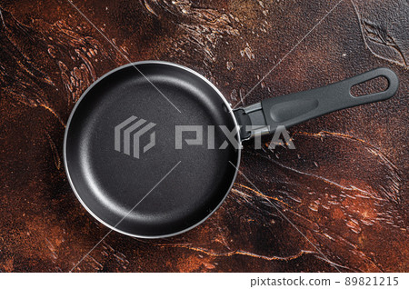 Empty iron frying pan on rustic table. Dark background. Top view. Copy space Empty iron frying pan on rustic table. Dark background. Top view. Copy space 89821215