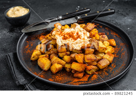 Patatas Bravas, traditional Spanish tapas, baked potato with spicy tomato sauce. Black background. Top view 89821245