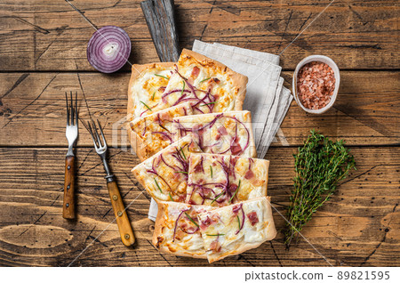 Flammkuchen or tarte flambee with cream cheese, bacon and onions. Wooden background. Top view 89821595