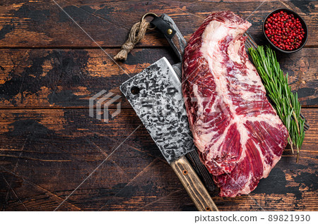 Hanging tender or hanger raw beef meat steak on butcher board with cleaver. Dark wooden background. Top View. Copy space 89821930
