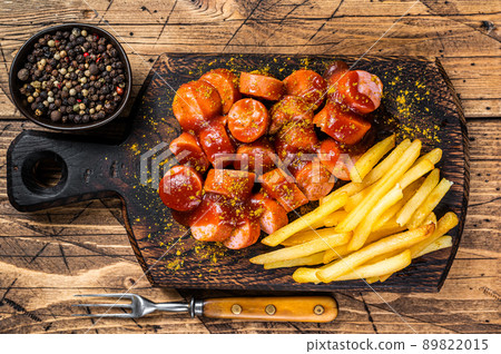 Currywurst Sausages street food served French fries on a wooden board. wooden background. Top view Currywurst Sausages street food served French fries on a wooden board. wooden background. Top view 89822015