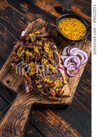 BBQ Texas Sandwich with slow roasted brisket beef meat. Dark wooden background. Top view 89822051