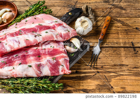 Fresh raw pork rack spareribs with thyme and garlic on cutting board. wooden background. Top view. Copy space 89822198