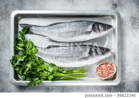 Raw sea bass or seabass fish in a baking dish. White background. Top view Raw sea bass or seabass fish in a baking dish. White background. Top view 89822240