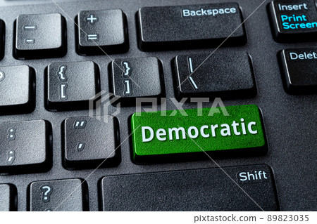 Democratic green key on a black desktop keyboard. Concept of voting online. Democratic green key on a black desktop keyboard. Concept of voting online. 89823035