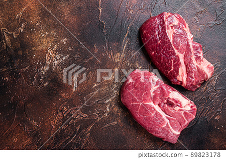 Raw Chuck eye roll beef steak on butcher table. Dark background. Top view. Copy space Raw Chuck eye roll beef steak on butcher table. Dark background. Top view. Copy space 89823178