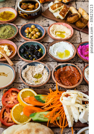 Delicious Turkish family breakfast table with pastries, vegetables, greens, spreads, cheeses, fried eggs, jams. Top view Delicious Turkish family breakfast table with pastries, vegetables, greens, spreads, cheeses, fried eggs, jams. Top view 89823213