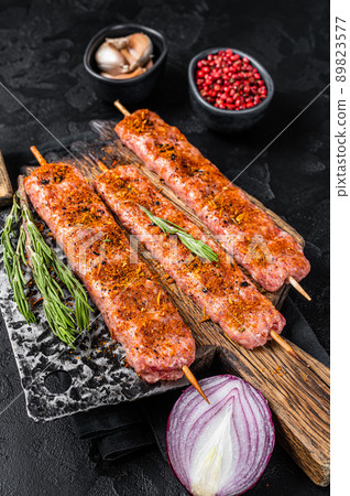 Raw Urfa shish kebab in butcher tray with herbs. Wooden background. top view. Copy space Raw Urfa shish kebab in butcher tray with herbs. Wooden background. top view. Copy space 89823577