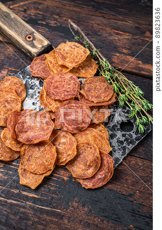 Meat Jerky on a butchery meat cleaver. Dark wooden background. Top view Meat Jerky on a butchery meat cleaver. Dark wooden background. Top view 89823636