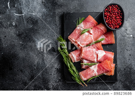Traditional Spanish Jamon Serrano ham on marble board. Black background. Top view. Copy space Traditional Spanish Jamon Serrano ham on marble board. Black background. Top view. Copy space 89823686