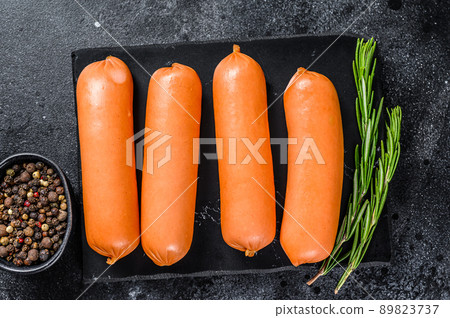 Raw barbecue sausages bratwurst on a marble board. Black background. top view Raw barbecue sausages bratwurst on a marble board. Black background. top view 89823737