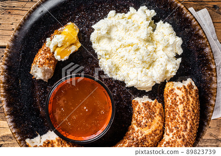 Tradirional Turkish breakfast - kaymak clotted cream, bagel simit and honey. Wooden background. Top view Tradirional Turkish breakfast - kaymak clotted cream, bagel simit and honey. Wooden background. Top view 89823739