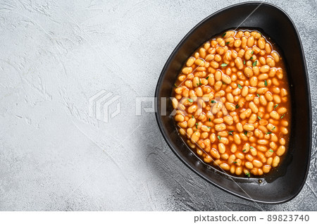 Baked beans in tomato sauce in a plate. White background. top view. Copy space 89823740