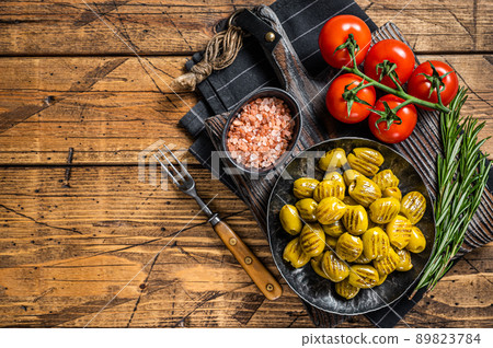 Barbecued organic olives with herbs in plate. Wooden background. Top view. Copy space 89823784