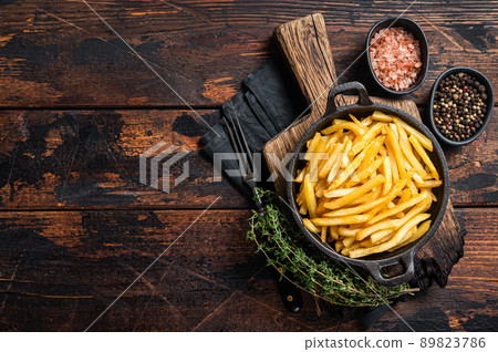Skilet full of Potato french fries with salt. Wooden background. Top view. Copy space Skilet full of Potato french fries with salt. Wooden background. Top view. Copy space 89823786