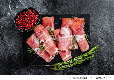 Traditional Spanish Jamon Serrano ham on marble board. Black background. Top view 89823788