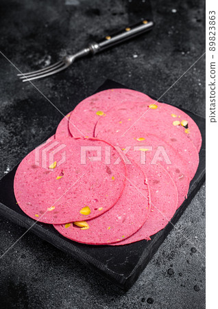 Slices of meat salami sausage with pistachios nuts on marble board. Black background. Top view Slices of meat salami sausage with pistachios nuts on marble board. Black background. Top view 89823863