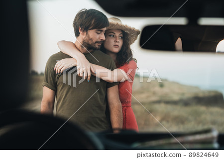 View Through Front Window of Car, Young Couple Man and Woman Having Fun Time Together Outdoors Near the Sea View Through Front Window of Car, Young Couple Man and Woman Having Fun Time Together Outdoors Near the Sea 89824649