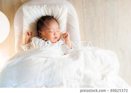 Baby sleeping with both arms raised at night Banzai sleeping copy space 89825372