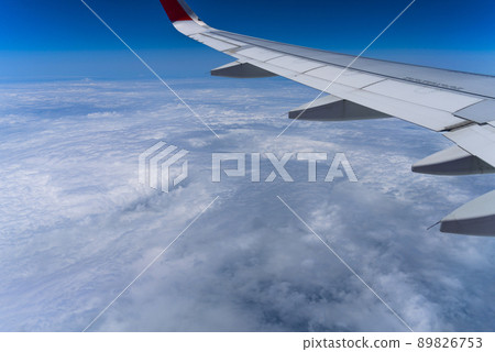 View of the sky from the window of an airplane Blue sky and flowing white clouds View of the sky from the window of an airplane Blue sky and flowing white clouds 89826753