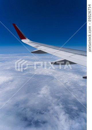 View of the sky from the window of an airplane Blue sky and flowing white clouds View of the sky from the window of an airplane Blue sky and flowing white clouds 89826754