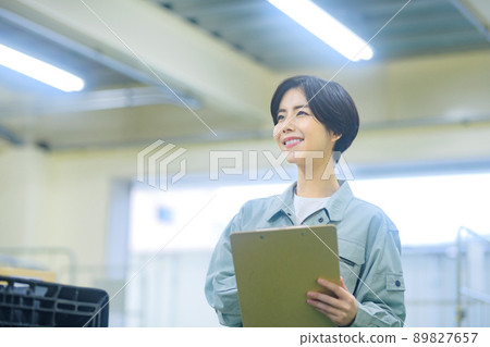 Female worker in inventory of work clothes to check luggage Female worker in inventory of work clothes to check luggage 89827657
