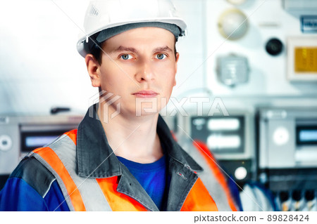 Portrait of young heavy industry engineer in protective vest and work clothes and helmet. Confident Portrait of young heavy industry engineer in protective vest and work clothes and helmet. Confident 89828424