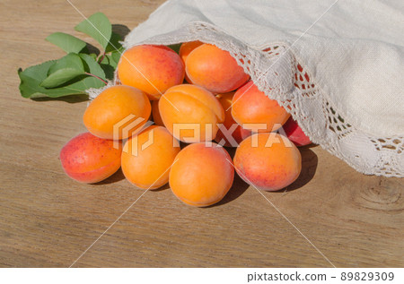 Ripe apricots and apricot leaves on the wood. Ripe apricots and apricot leaves on the wood. 89829309