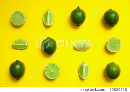 Flat lay composition with fresh juicy limes on yellow background 89829856