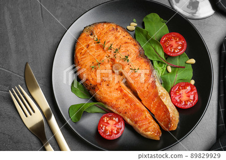 Delicious roasted fish served on grey table, flat lay 89829929
