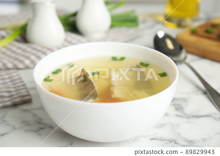 Delicious fish soup served on marble table, closeup Delicious fish soup served on marble table, closeup 89829943