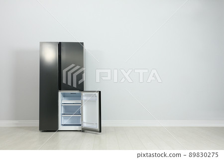 Modern refrigerator near light grey wall. space for text 89830275