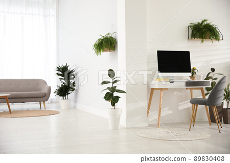 Modern workplace in room decorated with green potted plants. Home design Modern workplace in room decorated with green potted plants. Home design 89830408
