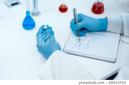 close up. a scientist writing down the formula for a new drug . close up. a scientist writing down the formula for a new drug . 89831010