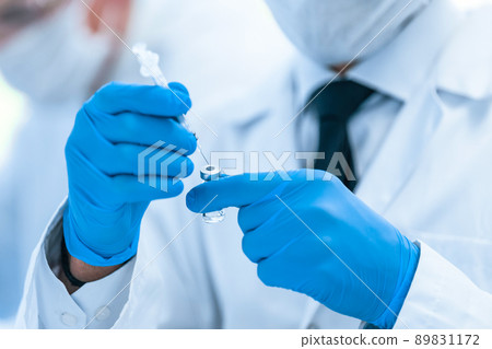 close up. scientist in protective gloves is testing a new vaccine . close up. scientist in protective gloves is testing a new vaccine . 89831172