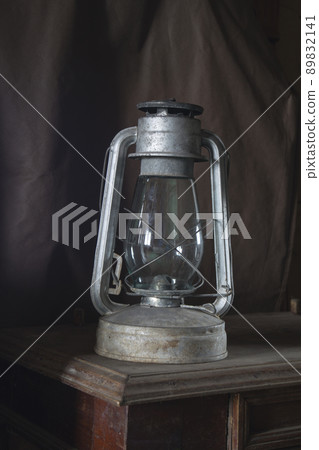 Aging kerosine lamp cost(stand)s on wooden table Aging kerosine lamp cost(stand)s on wooden table 89832141