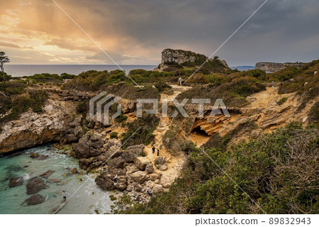 High angle view of tourists exploring cliff on island against cloudy sky 89832943