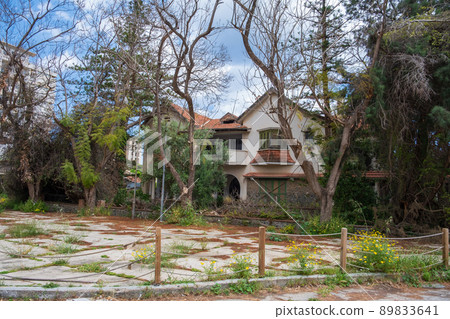 Wild vegetation in the yard of a beautiful abandoned house in the Ghost Resort City of Varosha Famagusta, Cyprus 89833641