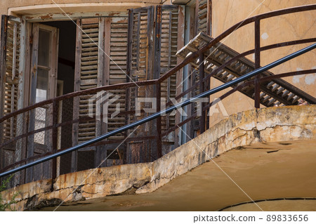 Broken woodne window and balcony of an abandoned house in the Ghost Resort City of Varosha Famagusta, Cyprus 89833656