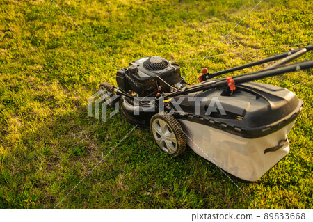 Close up view of grass mower and worker 89833668