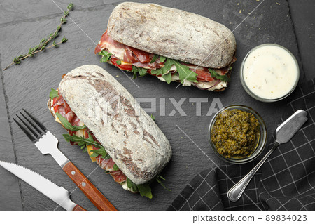 Flat lay composition with delicious sandwiches on grey table 89834023