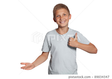 Close-up portrait of a blonde teenage boy in a white t-shirt posing isolated on white studio background. Concept of sincere emotions. Close-up portrait of a blonde teenage boy in a white t-shirt posing isolated on white studio background. Concept of sincere emotions. 89834347