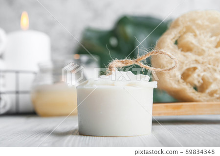 Natural loofah scrubber on podium in bathroom. Zero waste in life. Relaxation spa concept, candles, beauty.. 89834348