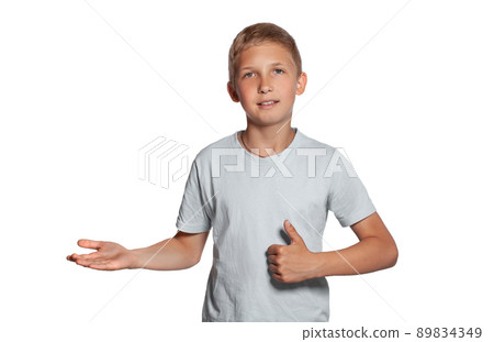 Close-up portrait of a blonde teenage boy in a white t-shirt posing isolated on white studio background. Concept of sincere emotions. Close-up portrait of a blonde teenage boy in a white t-shirt posing isolated on white studio background. Concept of sincere emotions. 89834349