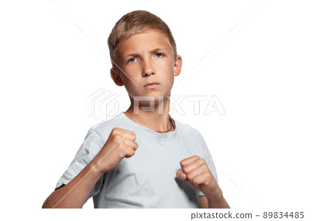 Close-up portrait of a blonde teenage boy in a white t-shirt posing isolated on white studio background. Concept of sincere emotions. Close-up portrait of a blonde teenage boy in a white t-shirt posing isolated on white studio background. Concept of sincere emotions. 89834485