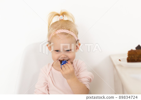 Funny baby with cochlear implant sitting at home and eating. Hear aid and medicine innovating technology concept 89834724