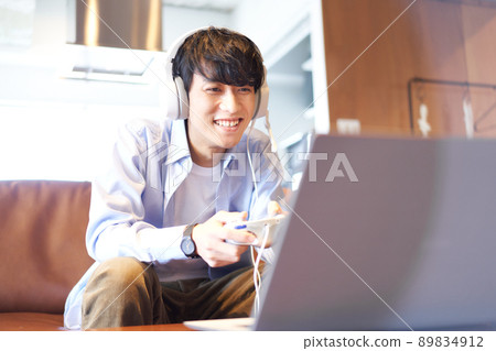 Young man sitting on the couch and enjoying the game 89834912