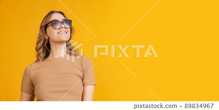 Portrait of young caucasian girl, student wearing brown outfit isolated on orange background. Concept of beauty, art, fashion, youth, monochrome Portrait of young caucasian girl, student wearing brown outfit isolated on orange background. Concept of beauty, art, fashion, youth, monochrome 89834967