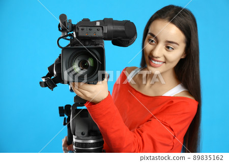 Operator with professional video camera on blue background 89835162